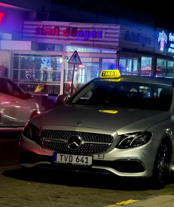 Mercedes taxi with lit roof sign at night in Nicosia